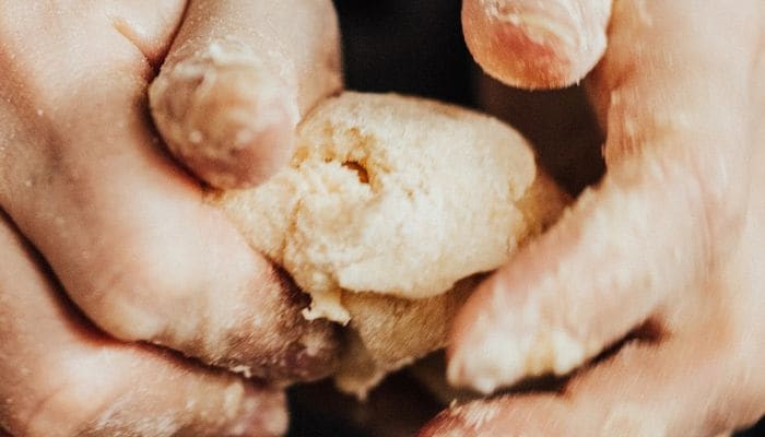 Hands kneading soft dough